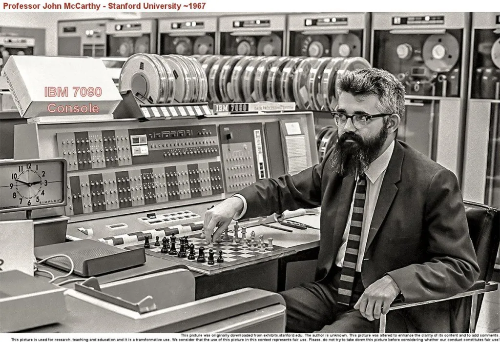 John McCarthy, padre de la IA, en una imagen en blanco y negro frente a uno de los primeros ordenadores IBM.
