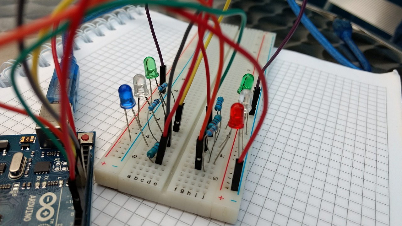 Protoboard con varios LEDs conectados con cables a una microcontroladora Arduino UNO.